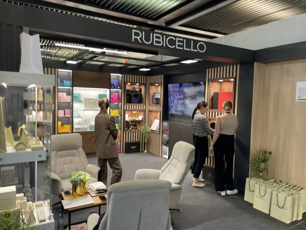 Stoisko Rubicello z opakowaniami na półkach i strefą rozmów