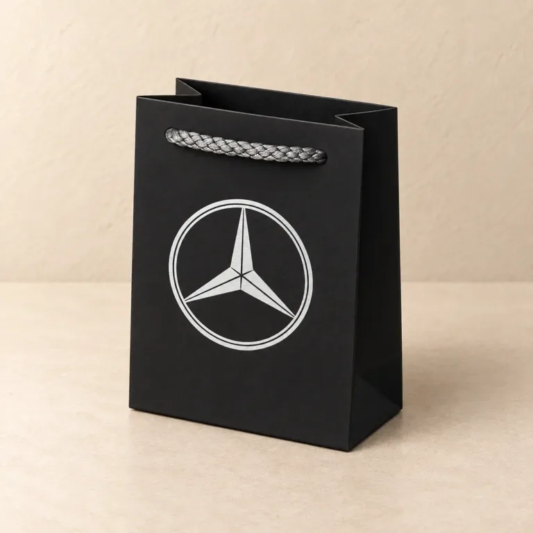Czarna torba papierowa T1 ze srebrnym logo Mercedes i srebrnym uchwytem sznurkowym